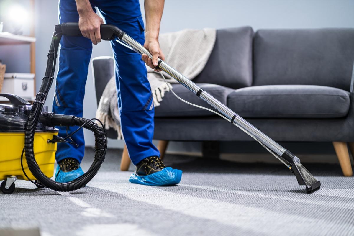 person-cleaning-carpet-with-vacuum-cleaner-picture-id1191080465